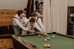 Washington wedding photographer capturing the groom playing pool at The Barn on Hinman in Cashmere, Washington
