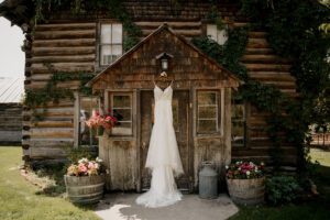 Wedding dress hanging in front of the rustic house at Brown Family Homestead in Leavenworth, WA