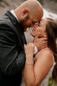 Couple eloping at Mt Baker with their foreheads together, about to kiss