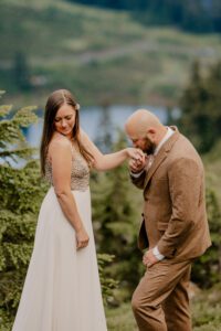 Groom kissing bride's hand during elopement in the Mt Baker Wilderness