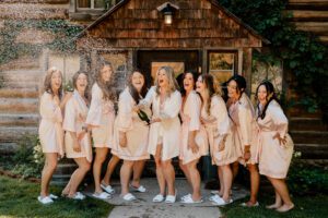Washington wedding photographer capturing the bridal party doing a champagne pop at Brown Family Homestead in Leavenworth, Washington