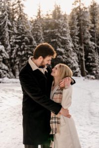 A couple celebrates after getting engaged at Lake Wenatchee in Leavenworth, WA