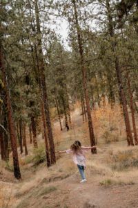 Senior portrait of a girl twirling in the forest of Leavenworth, Washington