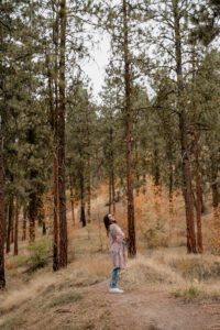 Senior portrait of a girl standing in the forest of Leavenworth, Washington