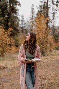 Senior portrait of a girl reading her Bible in the forest of Leavenworth, Washington