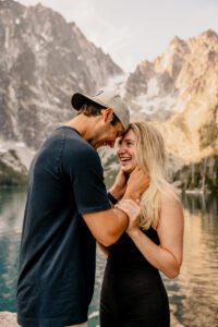 An engaged couple takes portraits in front of Colchuck Lake in Leavenworth, Washington