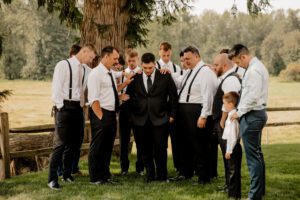 Men praying over the groom before the wedding ceremony at Machias Meadows
