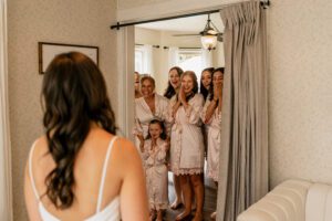 Bride doing a first look with her excited bridesmaids